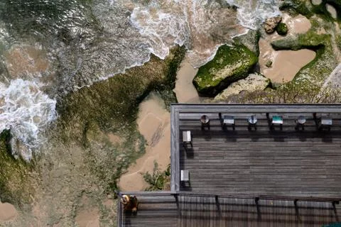 Aerial view of a decked seating area on a beach with a the sea coming in Stock Photos