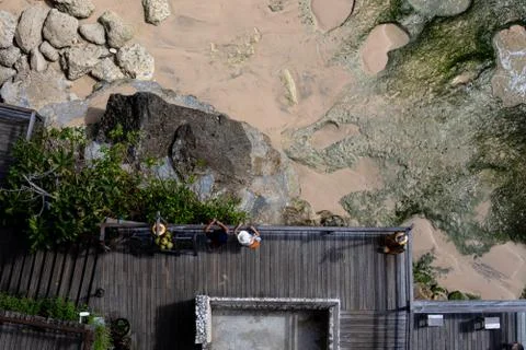 Aerial view of a decked seating area on a beach with a the sea coming in Stock-Fotos