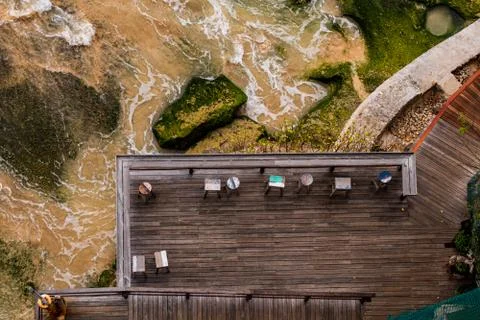 Aerial view of a decked seating area on a beach with a the sea coming in Stock Photos
