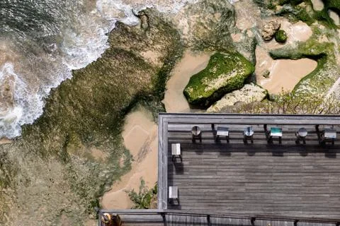 Aerial view of a decked seating area on a beach with a the sea coming in Stock-Fotos