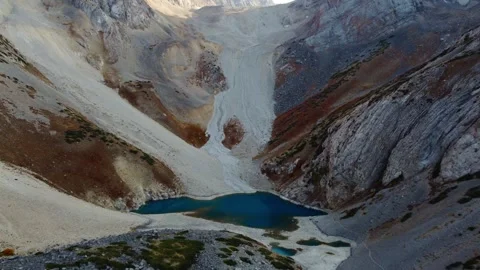 Aerial View of Deep Azure Glacial Lake and Barren Rocky Cliffs Video stock 332010178