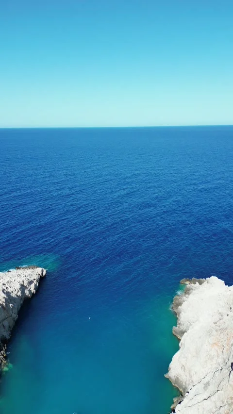 Aerial view of deep blue sea between rocky cliffs Stock Footage 325988752