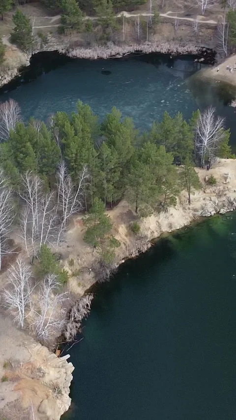 Aerial view of a deep, dark green lake Stockbeeldmateriaal 347499652