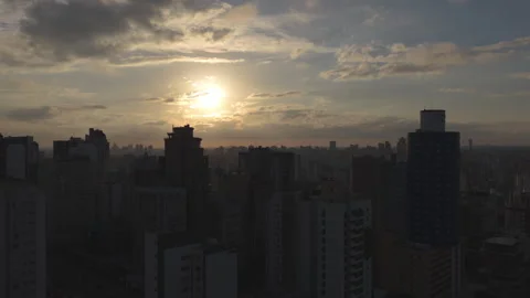 Aerial View of Dense City Skyline With Sun Behind Clouds - Curitiba Stock Footage 346070132