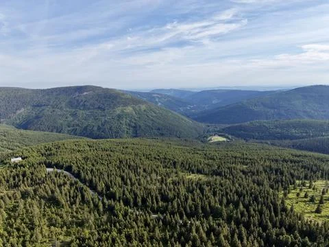Aerial view of dense conifer forest and rolling mountain ridges under a blu.. Stock Photos