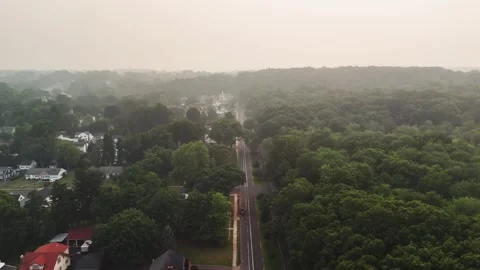 Aerial view of dense wildfire smoke drifting over a suburban forest... Video stock 340291071