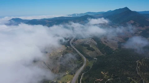 Aerial view descending through clouds to reveal busy road v2  Stock Footage 119571716