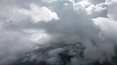 Aerial view descending through clouds to mountain valley Stock Footage 345384753