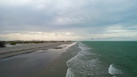 Aerial view of a deserted beach with waves and dark clouds Stock Footage 331020200