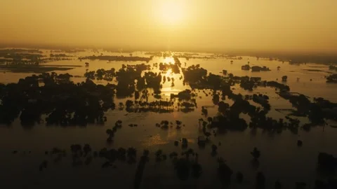Aerial view of a devastating flood in Pakistan at a golden, hazy sunset Stock Footage 319232310
