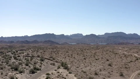 Aerial view of distant desert mountains, approaching a highway. Stock Footage 119397540