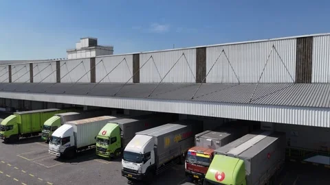 Aerial view of distribution warehouse with lorries in loading bays. Stock Footage 280092594