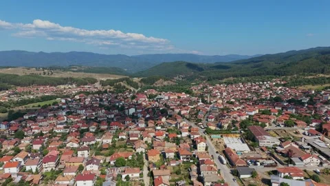 Aerial view of Dobrinishte town with red roofs and mountains in Bulgaria Stock Footage 343514574