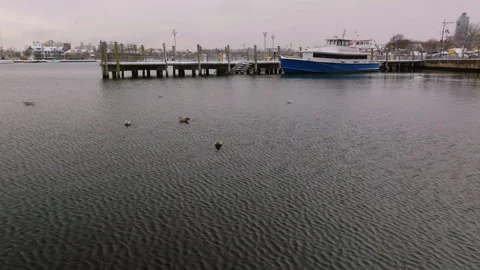 Aerial view of dock and boat on calm water in winter, ProRes 422HQ footage Stock Footage 332700569