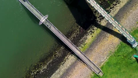 Aerial view of a dock extending over green water, with a small pavilion Stock-Footage 310901884