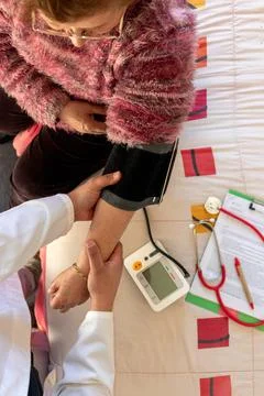Aerial view of a doctor's hands during a home visit, preparing an elderly w.. Stock Photos