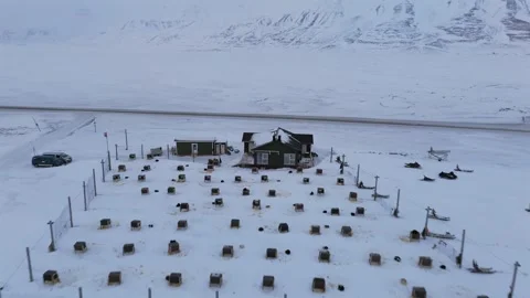 Aerial View of Dog Sledding Camp with Cabin and Mountain Backdrop in Svalbard Stock Footage 344076661