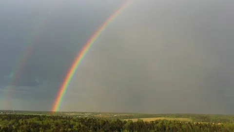 Aerial view of a double rainbow in the sky during rain,rainbow over villages and Stock Footage 154431288
