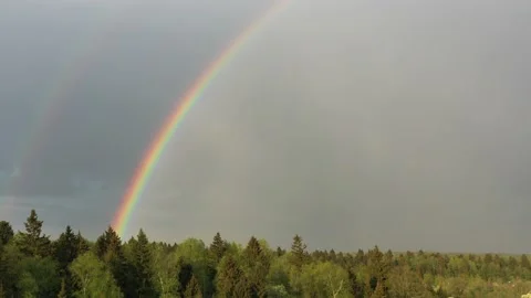 Aerial view of a double rainbow in the sky during rain,rainbow over villages and Stock Footage 155831085