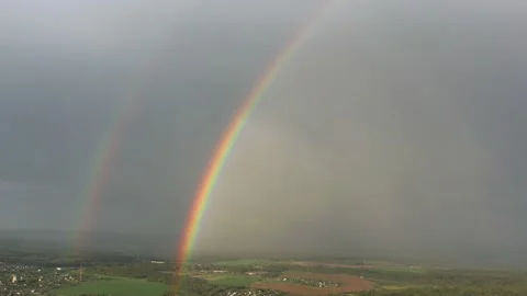 Aerial view of a double rainbow in the sky during rain,rainbow over villages and Stock Footage 156624022