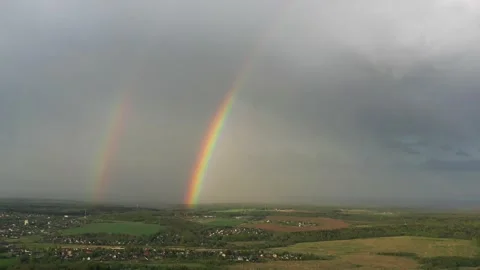 Aerial view of a double rainbow in the sky during rain,rainbow over villages and Stock Footage 157965546
