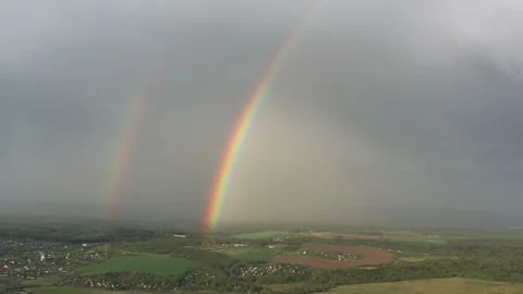 Aerial view of a double rainbow in the sky during rain,rainbow over villages and Stock Footage 158241859
