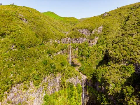 Aerial view of double waterfall surrounded with volcanic walls and forest. Stock Photos