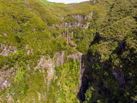 Aerial view of double waterfall surrounded with volcanic walls and forest. Stock Photos