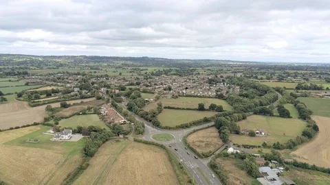 Aerial view, down and panning move. Cars on roundabout, houses and yellow stu Video stock 95562284
