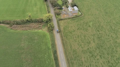 Aerial view, down move. Tractor with trimmer trims hedges on straight road Stock Footage 95395799