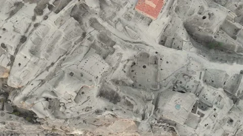 Aerial view down to structures of cave city with tunnels and chapel on the si Stock Footage 146581873