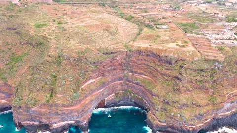Aerial view of dramatic cliffs and hidden beach cove on the coast of the Canary Stock Footage 311144636