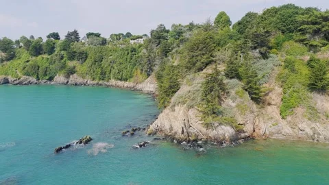Aerial view of the dramatic cliffs and lush greenery along the coastline of Stock Footage 346664979