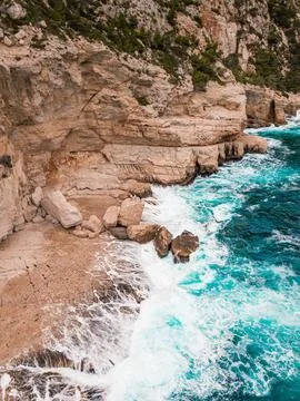 Aerial view of dramatic cliffs and turbulent waves along rugged coastline Stock Photos