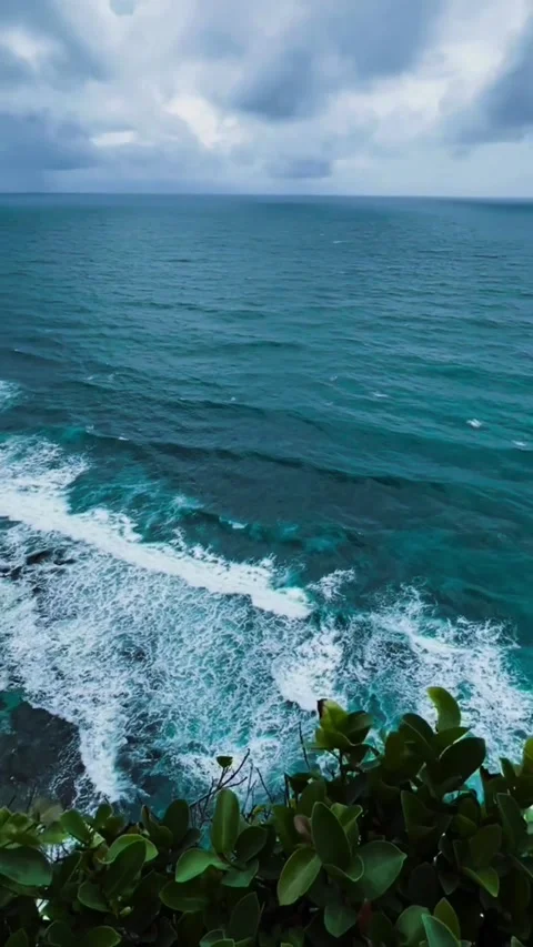 Aerial view of a dramatic cliffside coastline with crashing waves and deep blue Vídeos de archivo 334163138