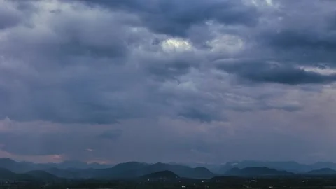 Aerial view of dramatic cloudy sky over mountain ridge at dusk with moody blue Stock Footage 314415380