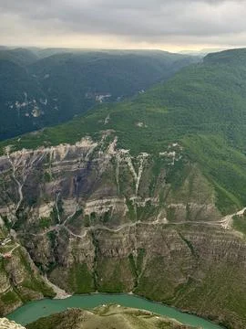 Aerial view of a dramatic mountain canyon with turquoise lake, forested slopes, Foto stock