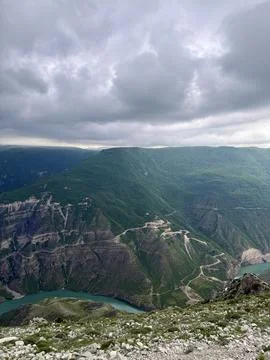 Aerial view of dramatic mountain canyon with turquoise river, forested slopes, w Foto stock