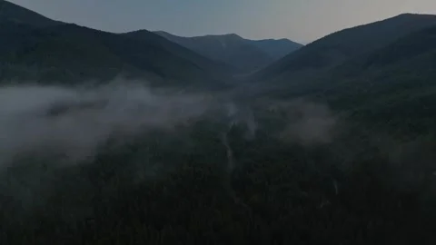 Aerial view of a dramatic mountain landscape with deep, forested valleys Stock Footage 323477164