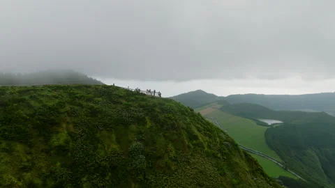 Aerial view of a dramatic mountain ridge viewpoint featuring a group of people Stock-Footage 335720659