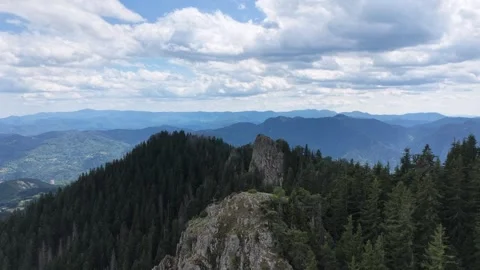 Aerial view of a dramatic rocky mountain ridge and summit cross surrounded by pi 動画素材 341801271