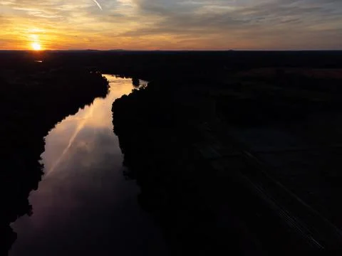 Aerial view of dramatic sunset reflecting on calm river with negative space Stock Photos