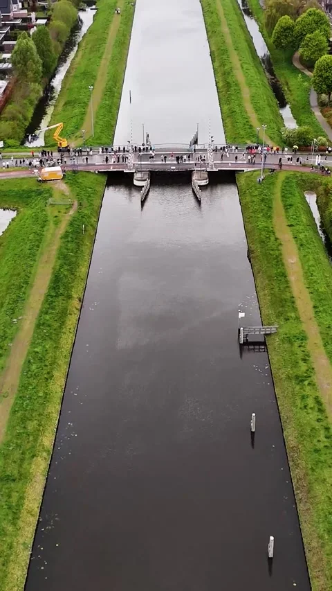 Aerial View Of Drawbridge Closing Over Dutch Canal With Pedestrians Waiting 库存影片 335476228