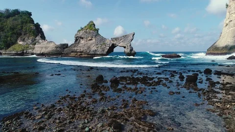 Aerial view by drone 4k camera. Rocks in a blue sea lagoon with breaking waves. Stock Footage 93718160