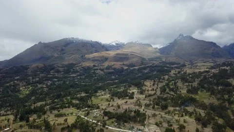 Aerial view from drone approaching several snow-capped mountains over pine Vidéo 164565282