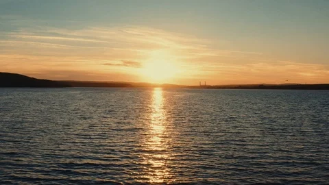 Aerial view of a drone camera back rays of the sunset and waves sea surface Stock Footage 105007931
