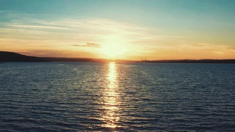 Aerial view of a drone camera back the rays of the sunset and waves sea surface Stock Footage 105008000