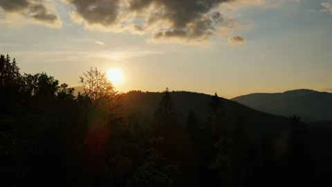 Aerial view drone cinematic shot of mountains at calm orange sunset Stock Footage 160144904