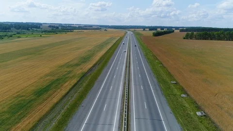 Aerial view Drone flies back over the highway through the fields Stock Footage 119142981