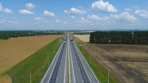 Aerial view Drone flies back over the highway through the fields Stock Footage 119144243
